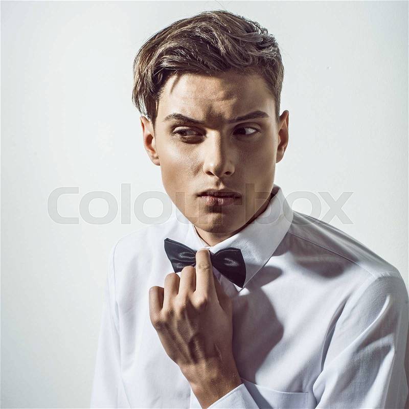 Portrait of beautiful handsome man with tie in white elegant shirt poses on studio background.Fashion look, stock photo