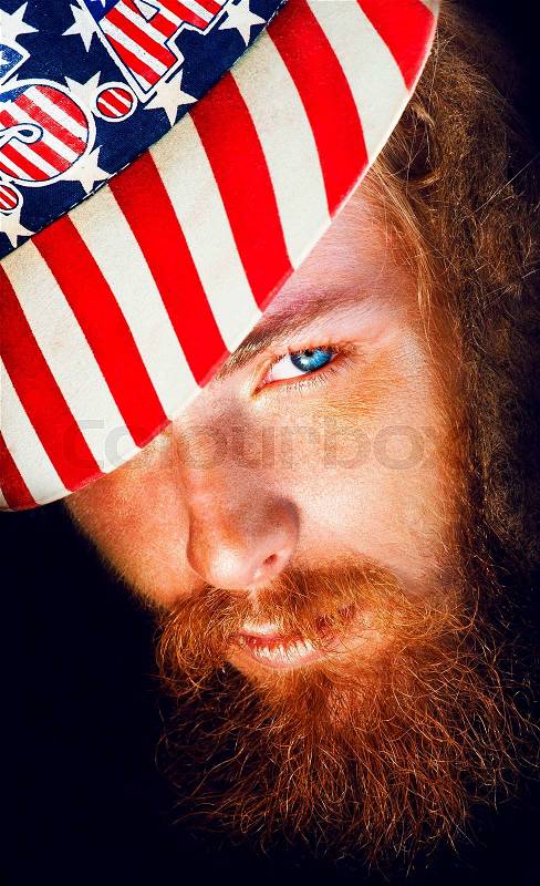Close up portait of ginger hipster with beard and colored cap, stock photo