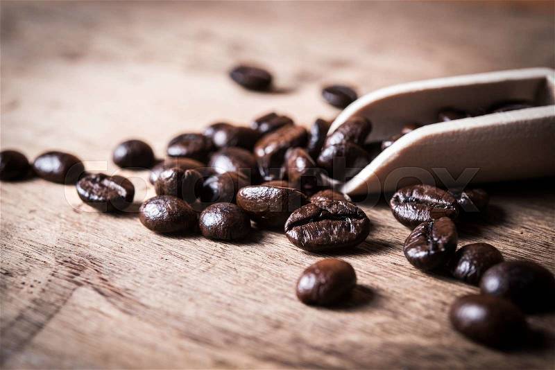 Coffee beans in wooden scoop, stock photo