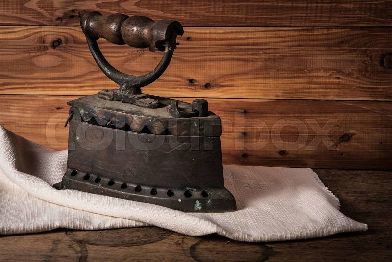 Old rusty iron on white cloth and wooden floor, stock photo