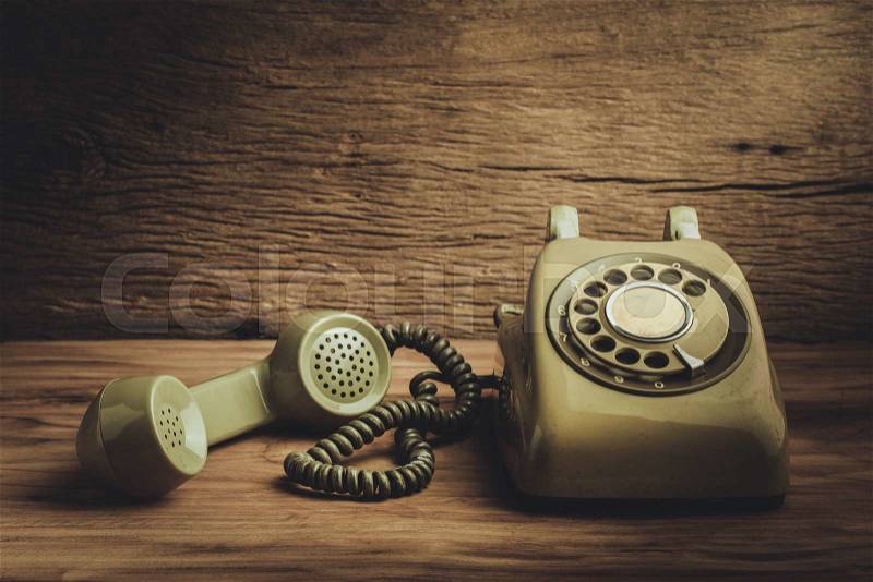 Still life with old green telephone on wooden table, stock photo