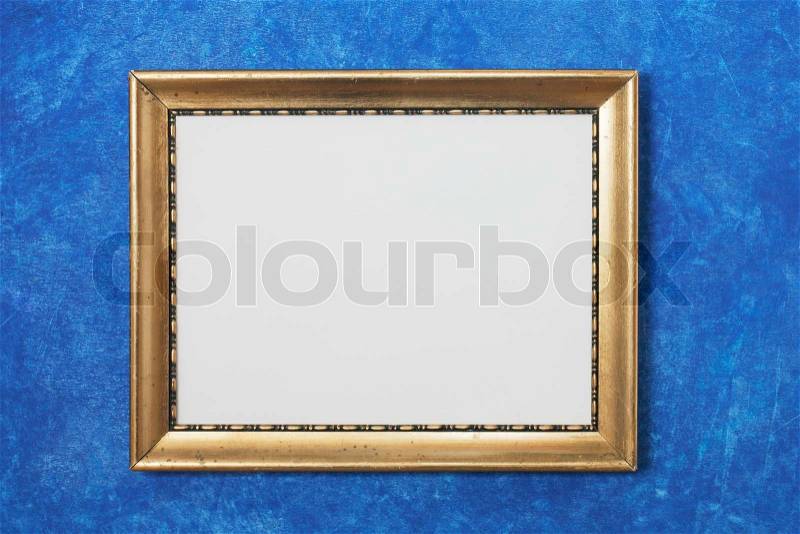 Old golden colored frame on blue, stock photo