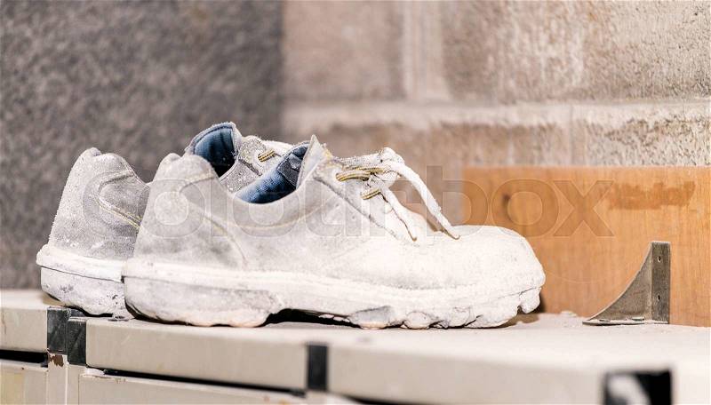 Dirty safety shoes in industrial environment, stock photo