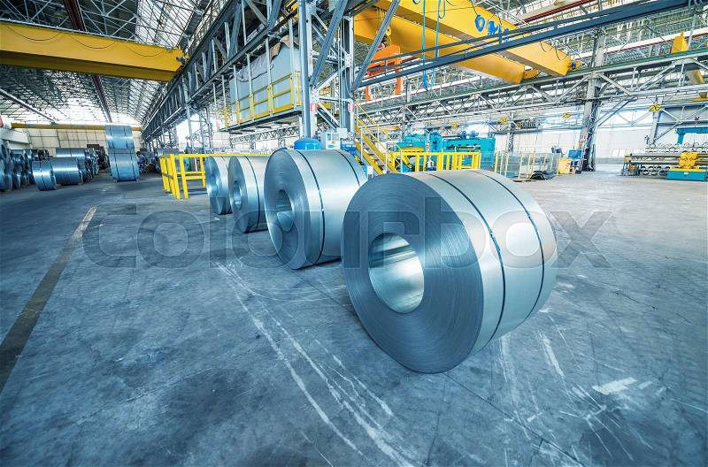 Cold rolled steel coils in storage area ready to feed to machine in metalwork manufacturing, stock photo