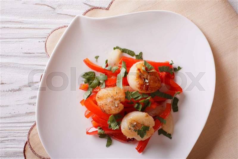 Grilled Scallops with peppers and herbs on a plate close-up. horizontal view from above , stock photo