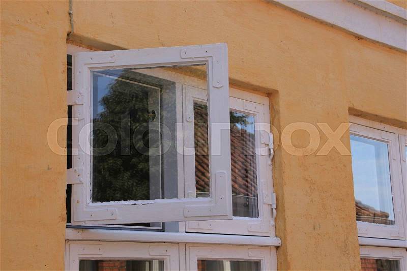 The window with reflection is open from the home in the residential area in the village in the hot summer, stock photo