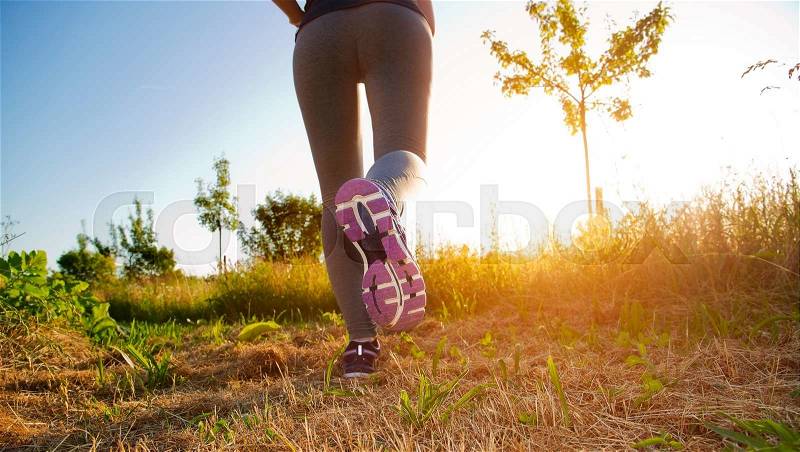 Fitness Girl running in a field with colorful outfit, stock photo