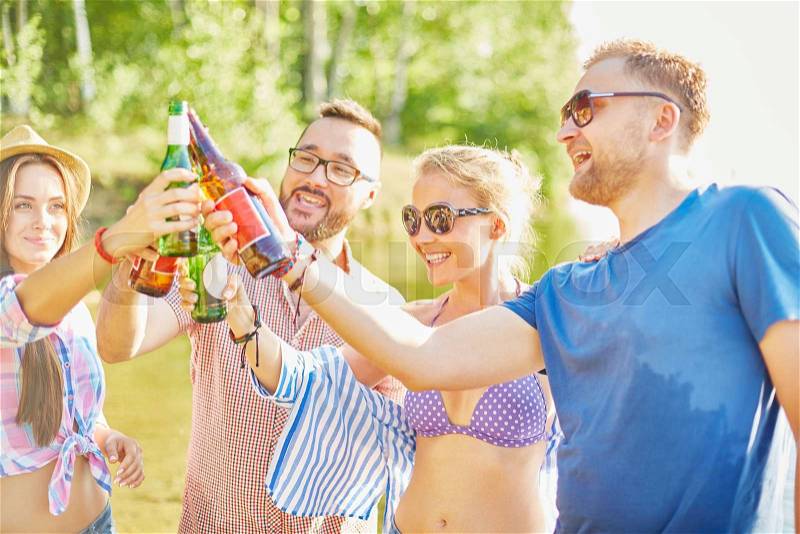 Happy friends with beer toasting during summer rest, stock photo