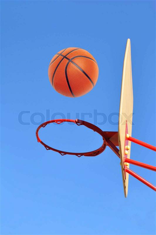 Basket hoop and basketball against blue sky, stock photo