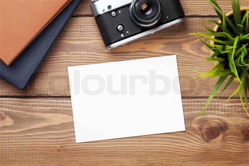 Blank photo frame or card, camera and supplies on office wooden desk table. Top view with copy space, stock photo
