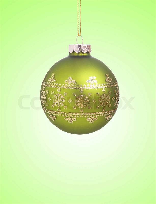 Green christmas ball with ribbon on green background with copy space for text, stock photo