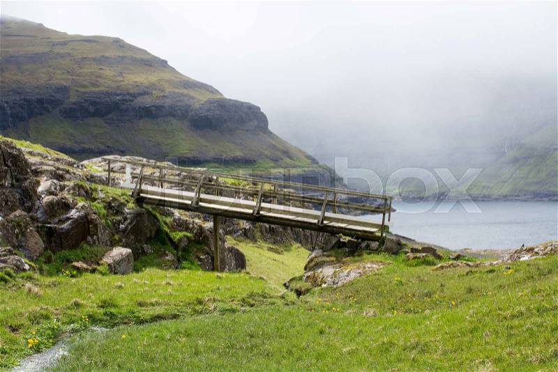 Typical landscape on the Faroe Islands, with green grass, rocks and bridge, stock photo