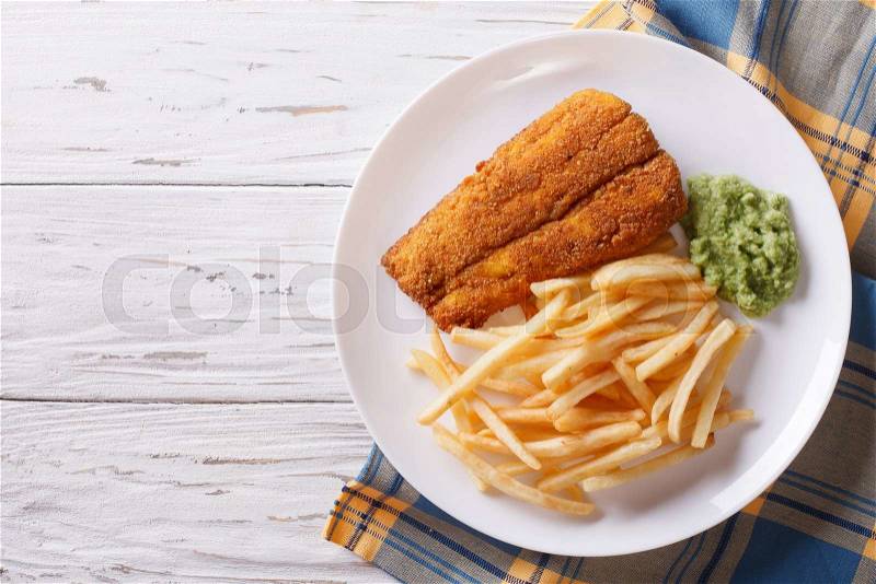 English food: fried fish in batter with chips and pea puree on a plate. horizontal view from above , stock photo