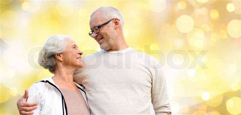 Family, relations, age and people concept - happy senior couple over holiday lights background, stock photo