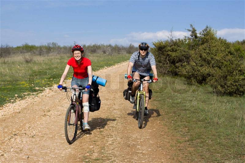 Bicycle travel. Couple of cyclists go to road. Bike Touring, stock photo