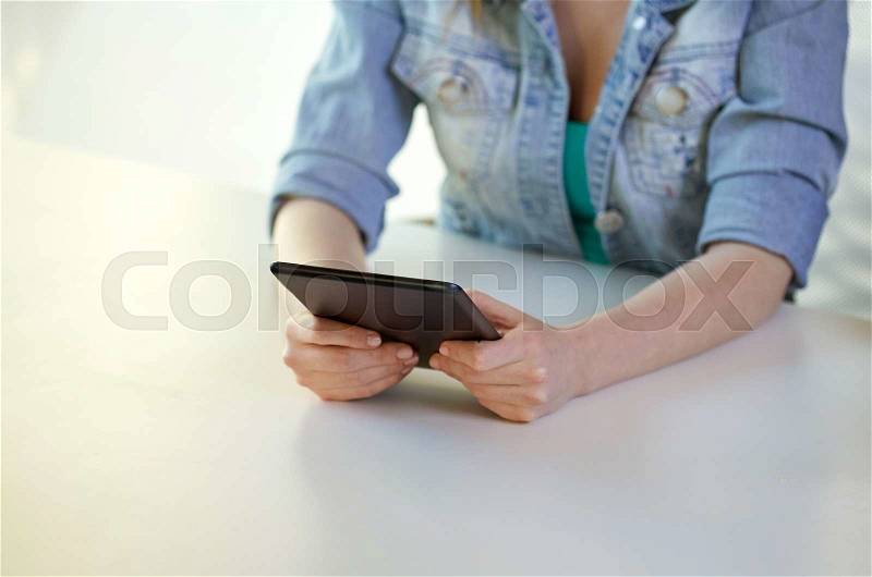 People, technology and internet concept - close up of female hands with tablet pc at table, stock photo