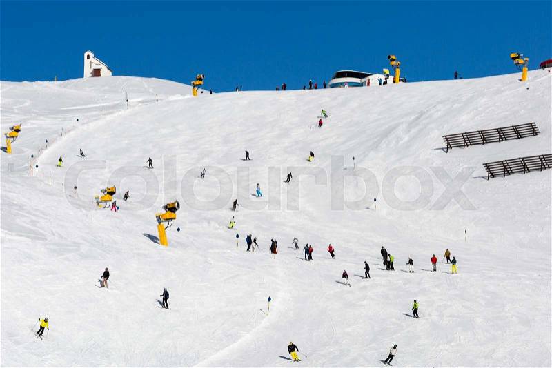 Skiers at ski run on a sunny day at the ski resort Soelden in Austria, stock photo