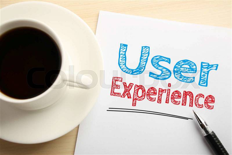 Text User Experience written on the white paper with pen and a cup of coffee aside, stock photo