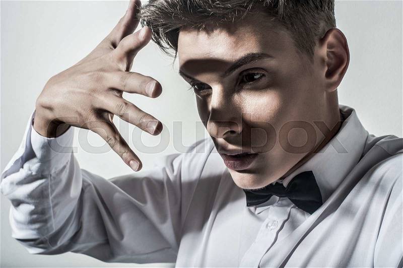 Portrait of beautiful handsome man with tie in white elegant shirt poses on studio background.Fashion look, stock photo