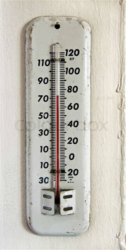 Vintage white enamel outdoor thermometer on the wall, stock photo