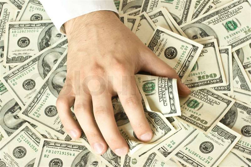 Greedy hand grabs money lot of dollars, stock photo