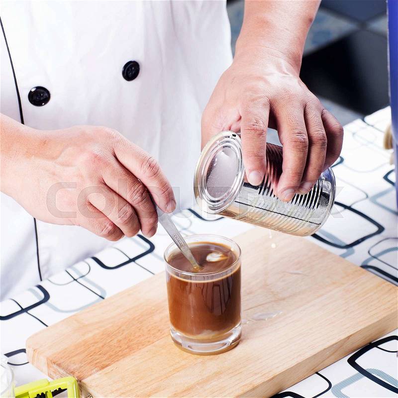 Chef putting a spoon in a coffee cup and stir, stock photo