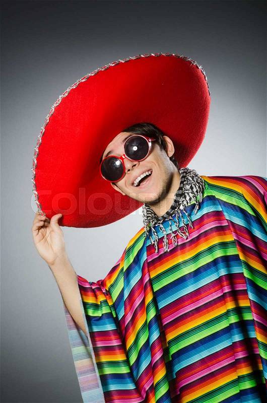Man in vivid mexican poncho against gray, stock photo
