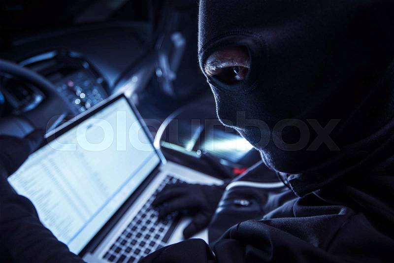 Hacker Inside the Car. Car Robber Hacking Vehicle From Inside Using His Laptop. Hacking On board Vehicle Computer, stock photo