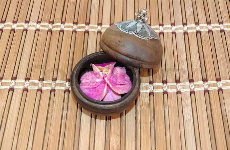 Decorative flower in wooden box on bamboo cloth, stock photo