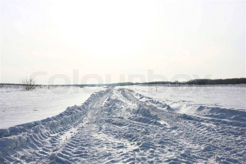 Snow covered road in winter with mountains in the distance, stock photo