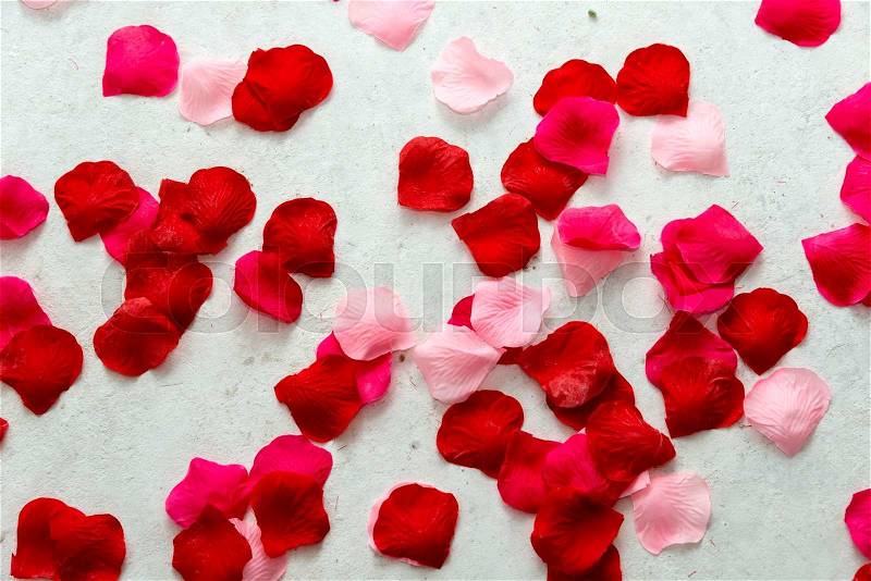 Red and pink imitation rose petals on concrete floor for marriage proposal, stock photo