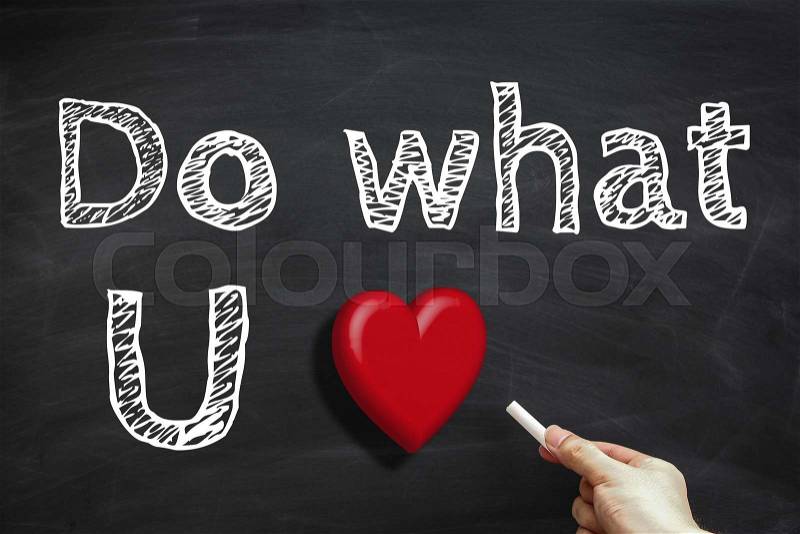 Hand with white chalk is writing the text Do what you love on the blackboard, stock photo