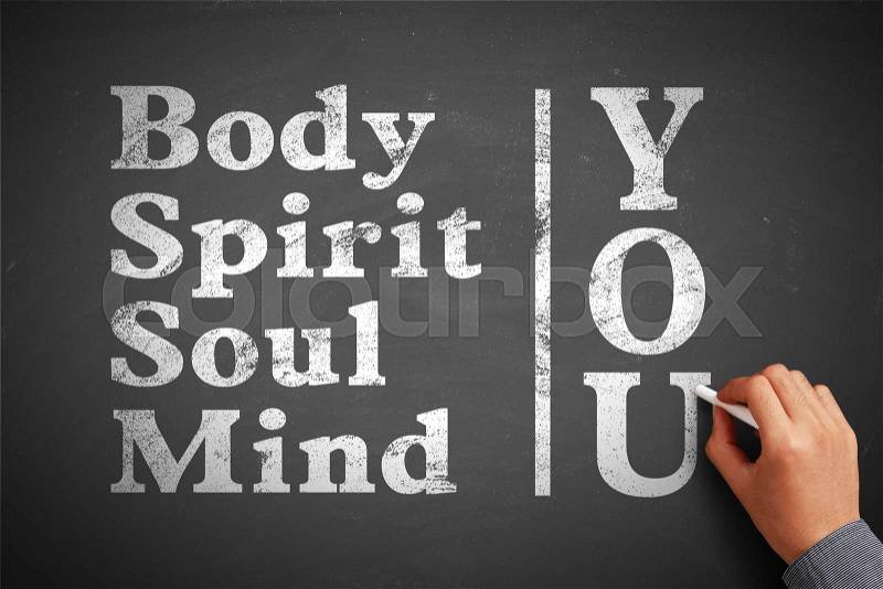 Hand with chalk is writing the concept of You Body Spirit Soul Mind on the blackboard, stock photo