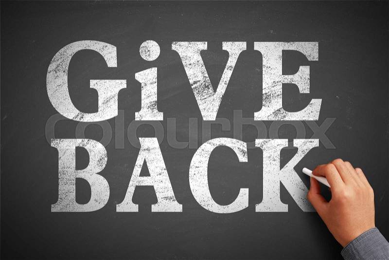 Hand with chalk is writing the concept of Give Back on the blackboard, stock photo