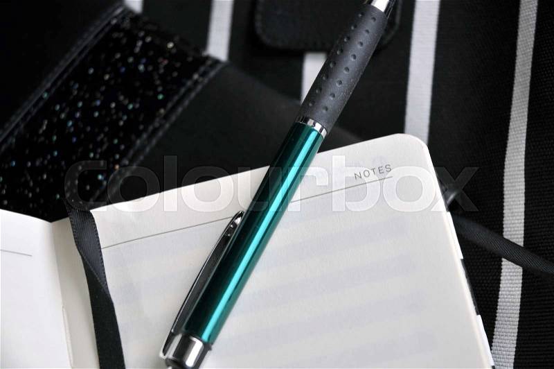 Green color pen put on blank notebook page , stock photo