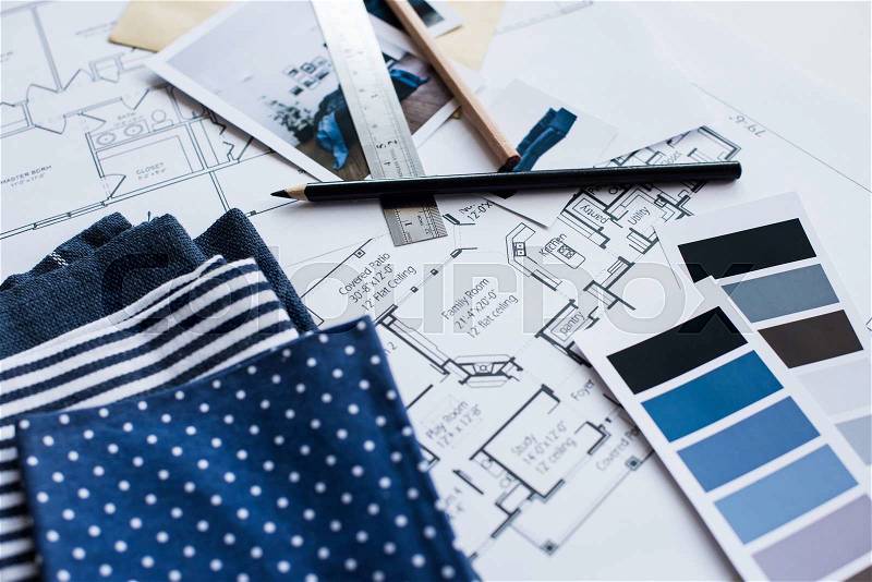 Interior designer\'s working table, an architectural plan of the house, a color palette, furniture and fabric samples in blue color. Drawings and plans for house decoration, stock photo