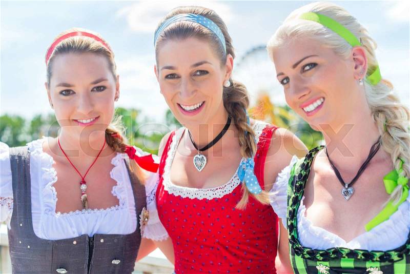 Women friends visiting Bavarian fair in national costume or Dirndl , stock photo