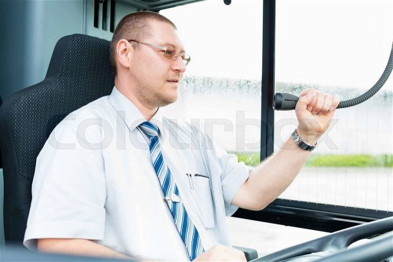 Bus driver making announcement using microphone, stock photo