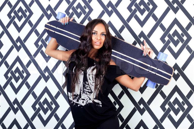 Beautiful brunette woman in black printed shirt poses with longboard on bright color studio background.Lifestyle.Sporty girl.Healthy life, stock photo