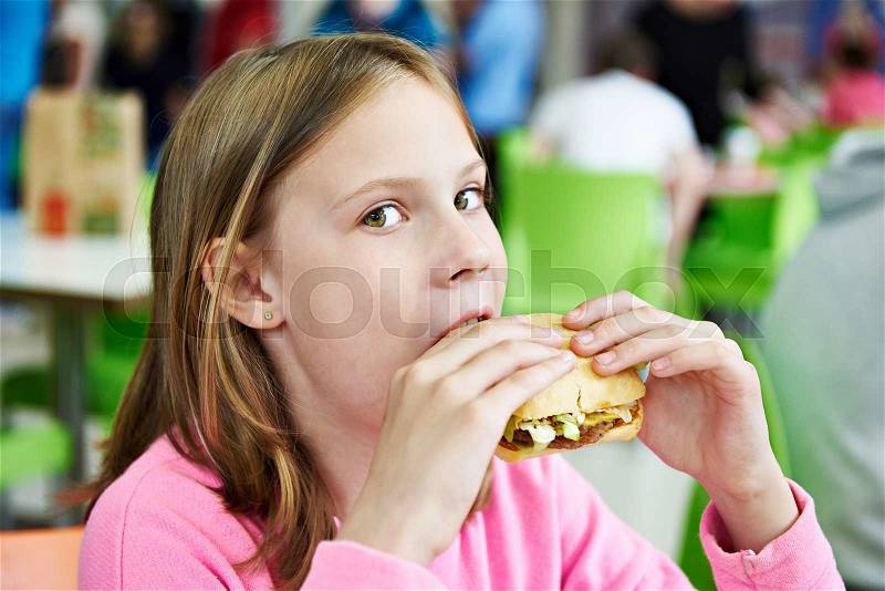 Girl eating a sandwich in a cafe, stock photo