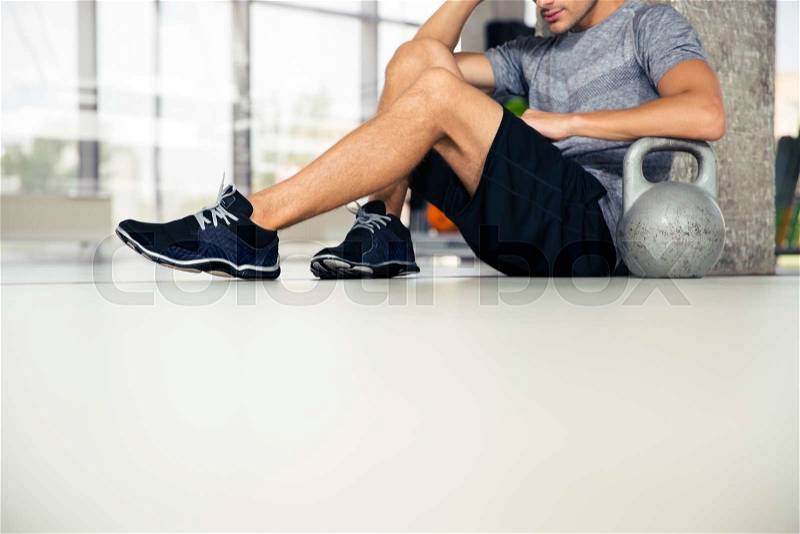 Closeup portrait of a man sitting on the floor at gym , stock photo