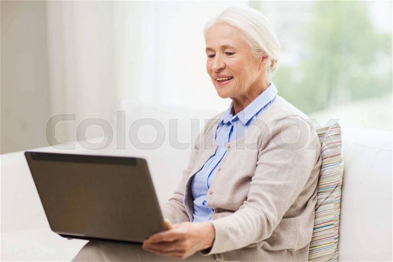Technology, age and people concept - happy senior woman with laptop computer at home, stock photo