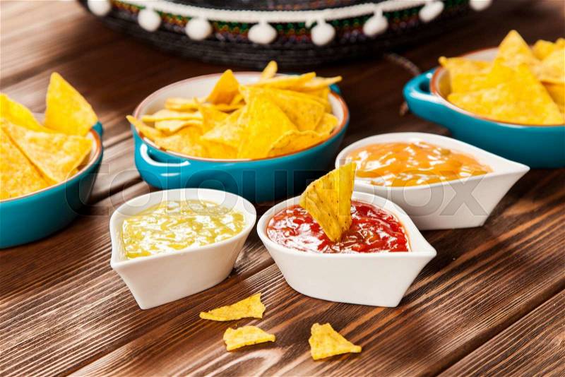 Plate of nachos with salsa, cheese and guacamole dips, stock photo