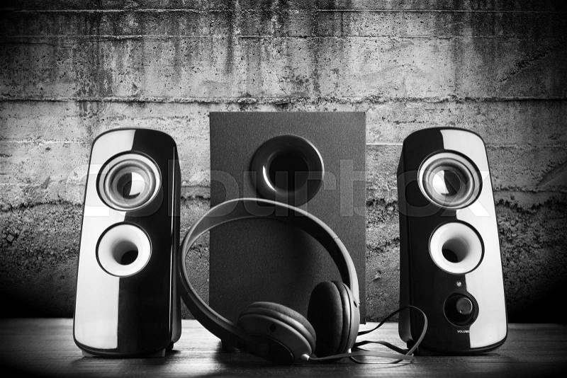 Modern black sound speakers and headphones on dark background, stock photo