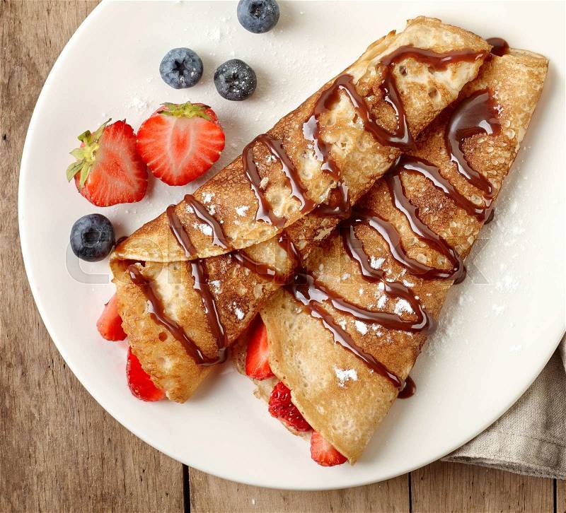 Crepes with strawberries and chocolate sauce, stock photo