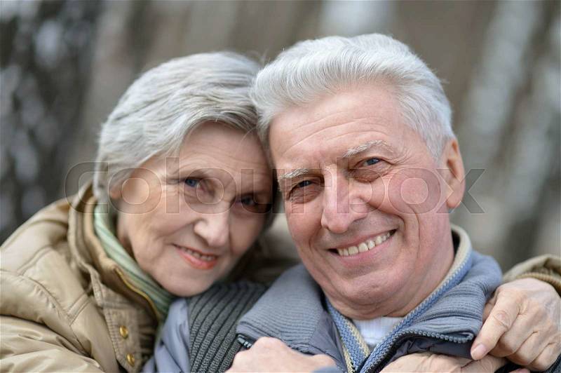 Happy elder couple on a walk in nature in autumn, stock photo