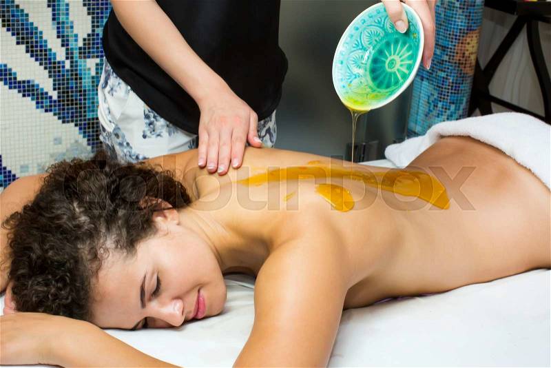 Processes honey massage girl in a spa salon, stock photo