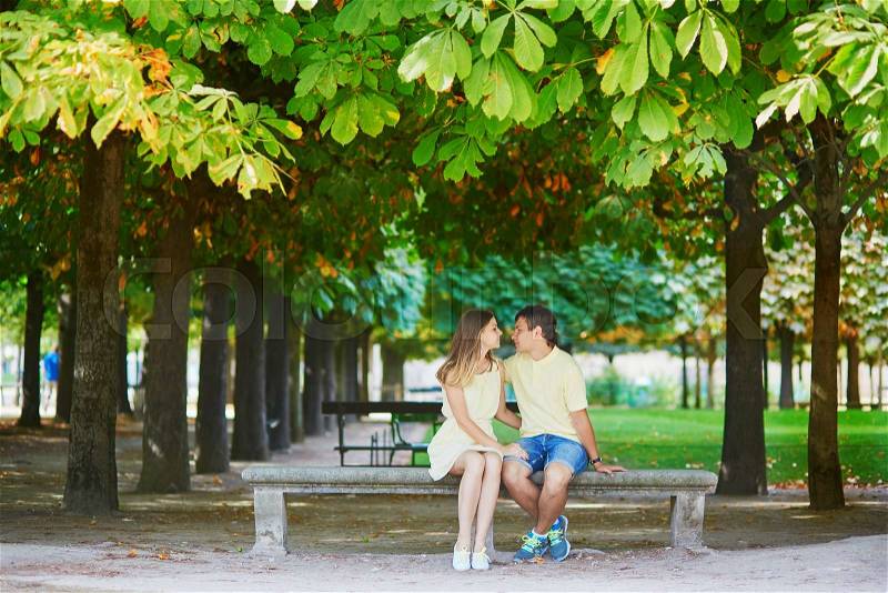 Beautiful young dating couple in Paris in the Tuileries garden on a warm and sunny autumn day, stock photo