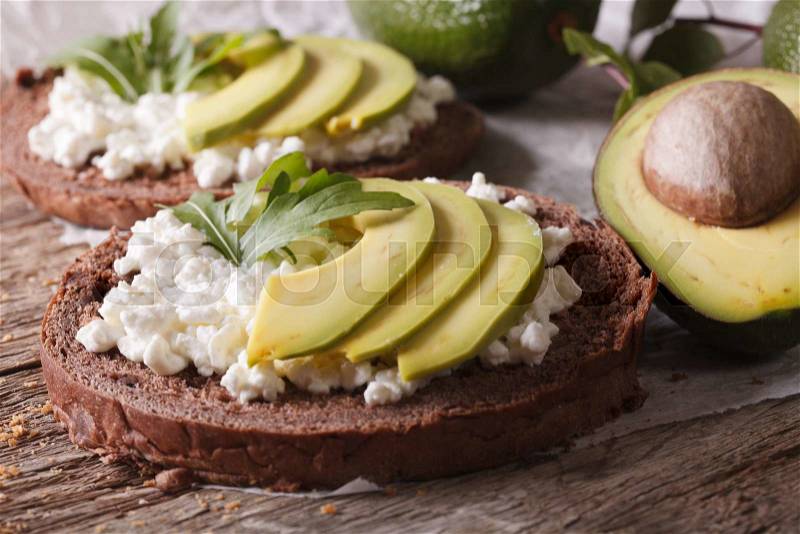 Healthy sandwiches with avocado, cream cheese and arugula close-up on the table. horizontal , stock photo