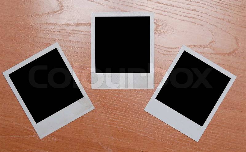 Polaroids isolated on wooden background, stock photo
